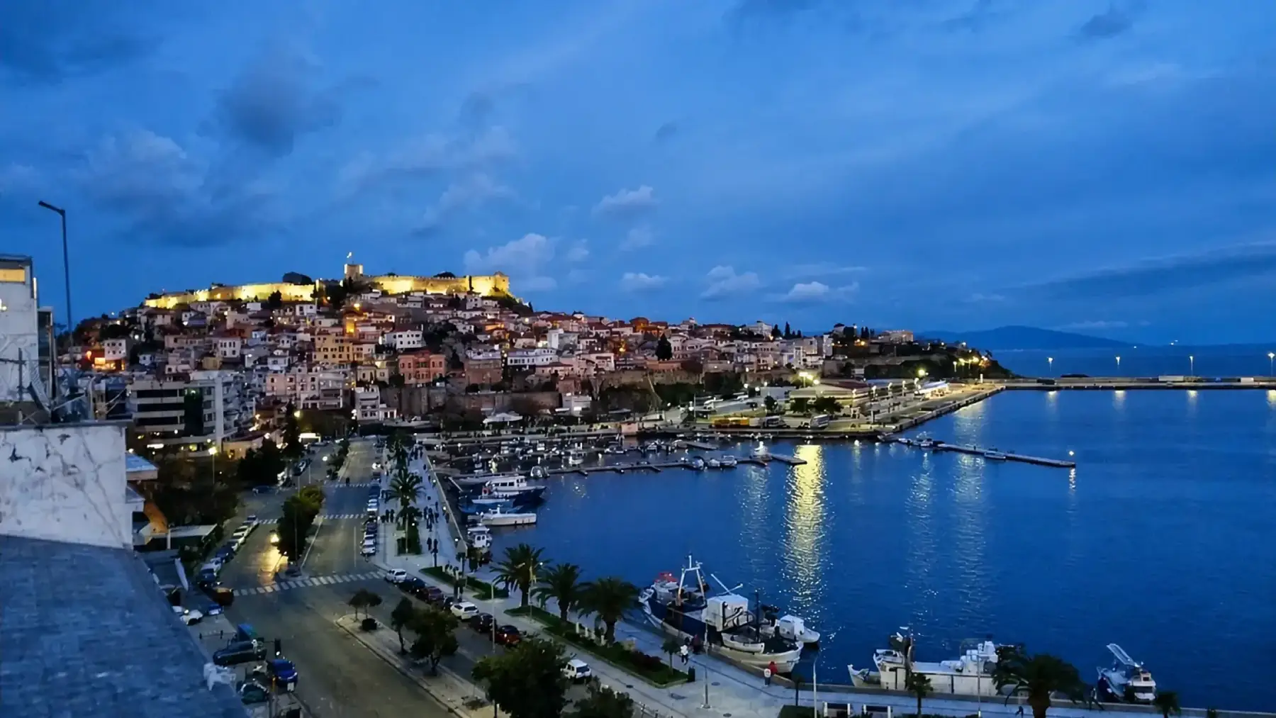Kavala at dusk, the lit castle above the old town and the harbour below
